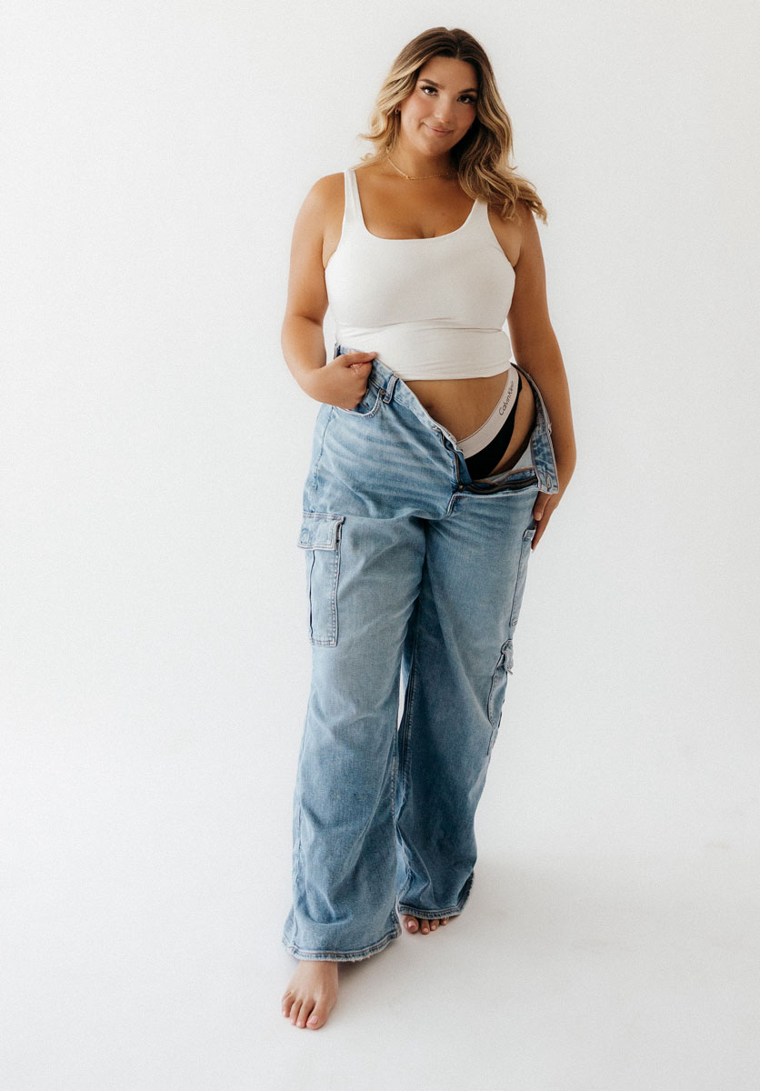 The coach is posing while holding her pants.